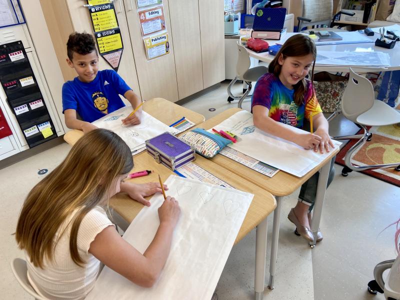 Students (l-r) Delaney Keating, Luke Little and Elyse Van Heest decorate their kites.